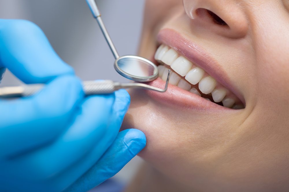 Dentist,Examining,A,Patient’s,Teeth,In,The,Dentist. Dentist,Examining,A,Patient's,Teeth,In,The,Dentist.